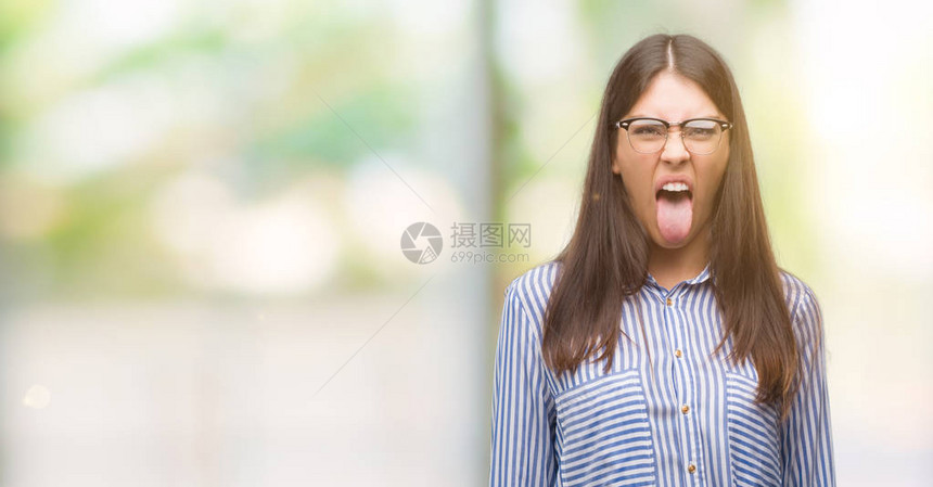 年轻美丽的西班牙女商人用可笑的表情说出快乐的舌头情感概念图片