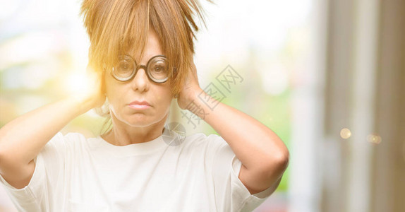 疯狂的中年妇女戴着愚蠢的眼镜捂住耳朵图片