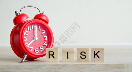 RISK用时钟时间风险概念在木块上的图片