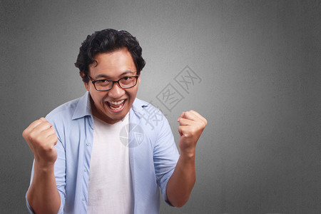 年轻亚裔男子穿着白蓝衬衫快乐的表情图片