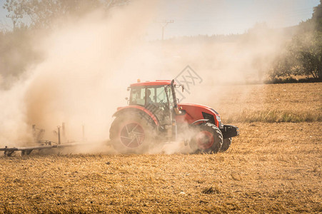 红色拖拉机耕种田地农图片