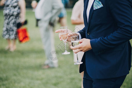 现代人的手用香槟杯豪华婚礼招待会丰盛的庆祝活动来欢呼图片