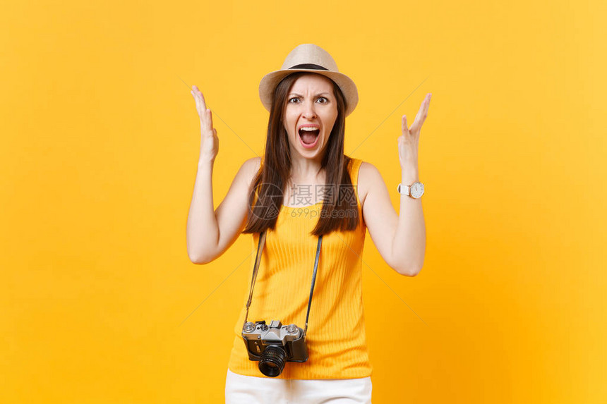穿着夏季休闲服戴着复古老式照片相机的帽子黄色橙背景中突显的震惊旅游女周末出国旅行的女孩度假空中图片