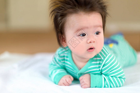 新生婴儿男孩躺在地毯图片