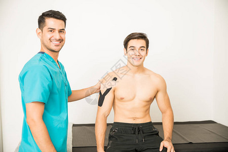 男医生的肖像和病人在诊所动脉磁带治疗图片