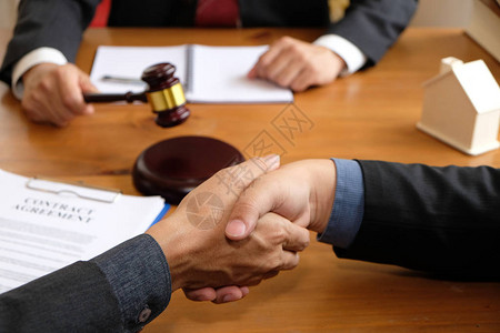 商人在讨论拍卖合同协议后与律师握手在律师事务图片