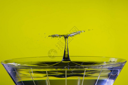 下降的一滴水在马提尼杯上与不断上升的喷洒柱相碰撞图片