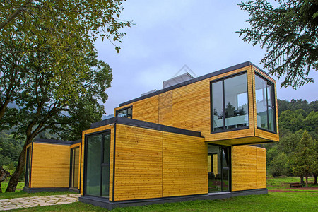 大自然的木屋现代设计建筑与木房子的住房概念绿色森图片