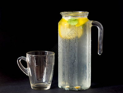 新鲜柠檬水罐装着玻璃薄荷和柠檬在黑图片