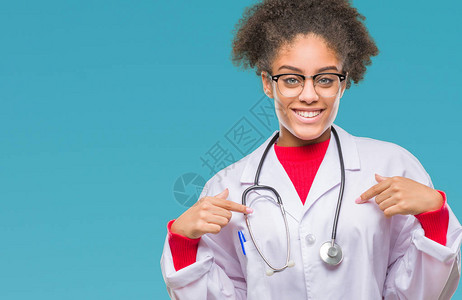 身处孤立背景的年轻美国女医生满怀自信面带笑容骄傲和快乐地用手指对着图片