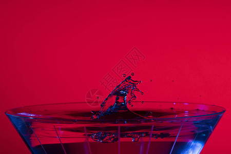 红底和蓝色液体亮点的马提尼杯图片