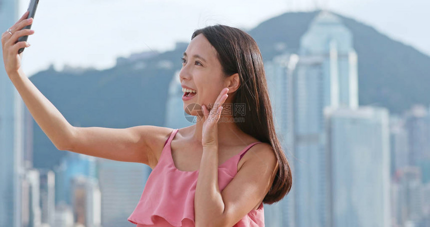 在香港城市用手机拍摄光子的女人图片