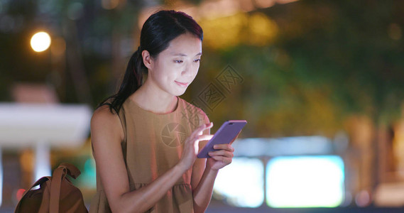 女人晚上看智能手机图片