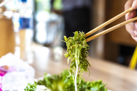日本海藻沙拉在筷子上手边图片