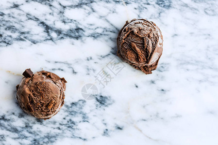 大理石背景上的巧克力冰淇淋勺顶视图图片