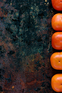 黑色金属质朴背景上的柿子果实图片