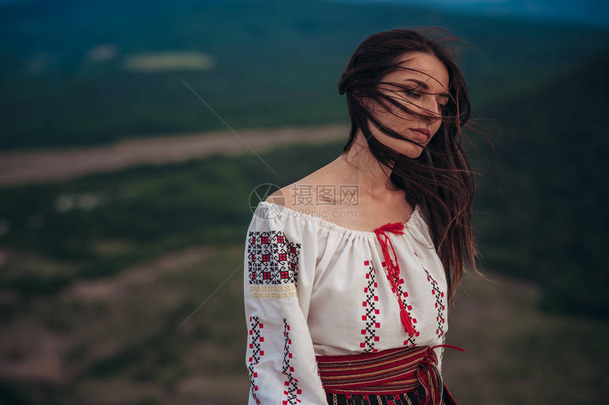 有吸引力的女人在山绿色的传统罗马尼亚服装模糊背景户外照片传统图片