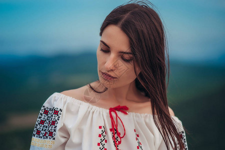 有吸引力的女人在山绿色的传统罗马尼亚服装模糊背景户外照片传统图片