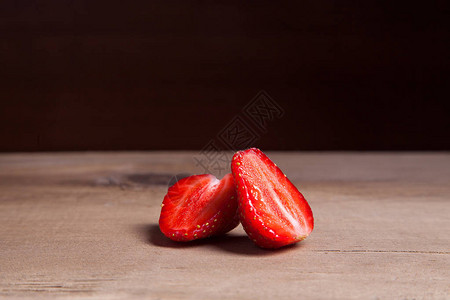 甜草莓切片一半和整个浆果复古背景上木制背景中新鲜成熟的图片