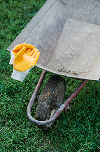 园艺工具独轮车和黄色手套园艺工具在春季和春季庭院清洁概念图片