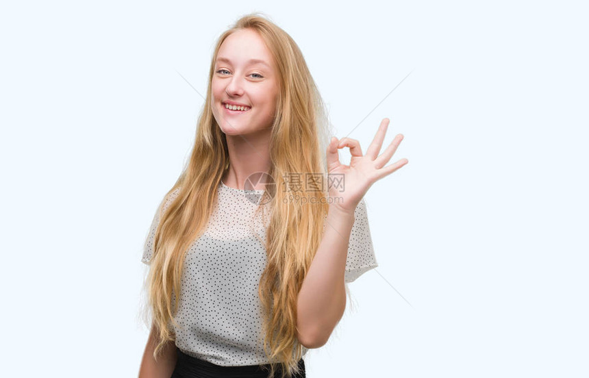 穿着痣衬衫的金发少女微笑着积极地用手和指做ok的手势图片