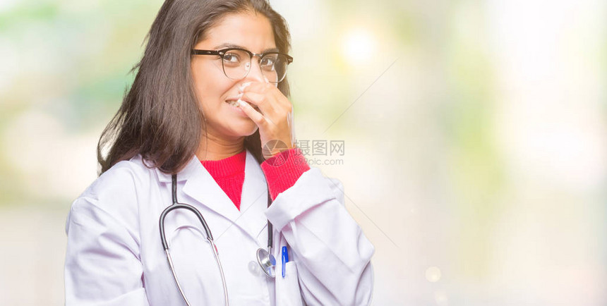 年轻的阿拉伯医生女人在与世隔绝的背景下闻到某种臭味和恶心难以忍受的气味图片