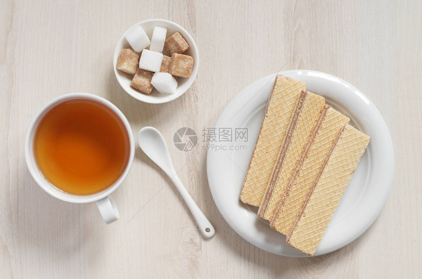 白色盘子里有巧克力和茶杯的衣物在桌子图片