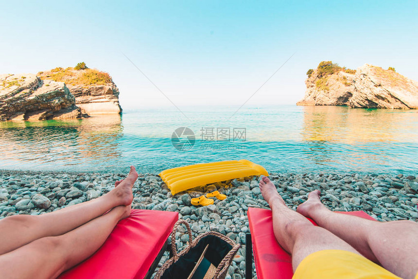 两对情侣躺在太阳休息室美丽的海景和岩石的图片