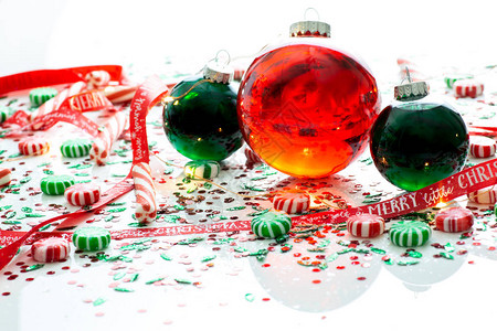 用红色液体填充的圣诞装饰球和两个绿色填充的装饰球装饰背景图片