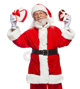 圣诞节戴着白手套的微笑圣诞老人拿着两个带丝的红白心形礼盒慷慨礼物的概念在白背景图片