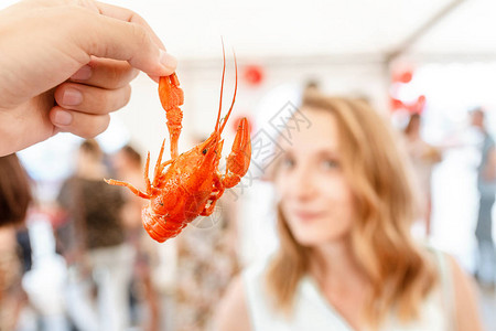 年轻妇女食用红锅煮的美味龙虾或龙虾图片