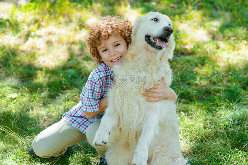 拥抱一个小男孩最喜爱的宠物卷发红色美极了柔软的猎手图片