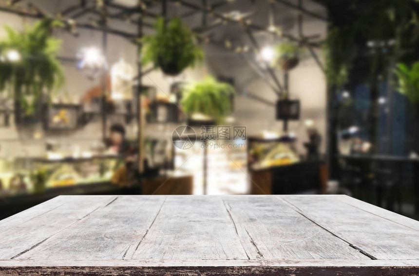 选定的焦点空棕色木桌和咖啡店或餐厅模糊背景与散景图像用于您的照片蒙太图片
