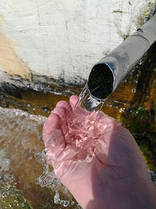 用自流清洁水和一只手装满来自Jarylgach岛的液体图片
