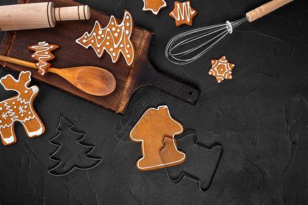 圣诞自制姜饼香料和深色背景上的切菜板图片