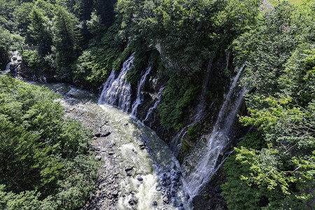 美丽的瀑布从悬崖流向河流图片