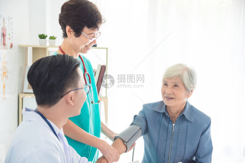 在医院检查高级妇女血压的亚洲医生和护士图片