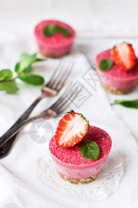 Vegan甜点白桌上配有薄荷和新鲜草莓的粗生图片