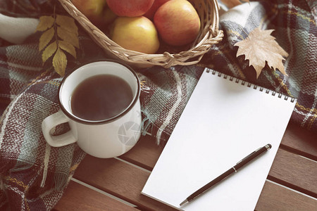 用笔写热茶杯和毛毯苹果笔记本和古老木本底的秋叶温图片