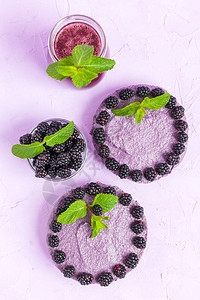 生黑莓甜点装饰着新鲜成熟的森林浆果和绿薄荷叶图片
