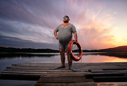 发胖超重回过水游泳在湖边在日图片