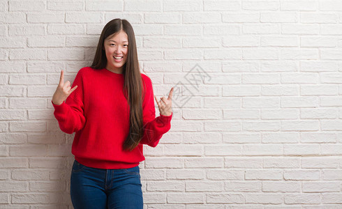 年轻的女人在砖墙上高喊着疯狂的表情图片