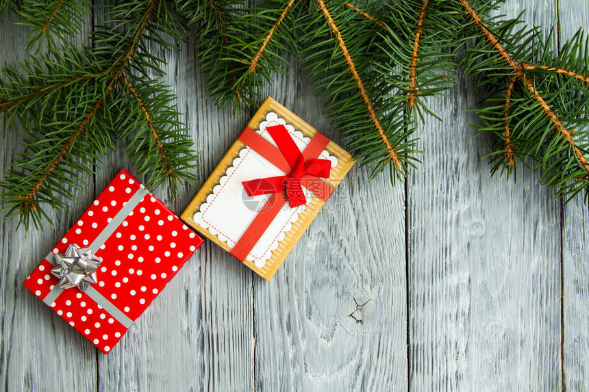 两件圣诞礼物放在一个节日盒里在灰色的旧木背景图片