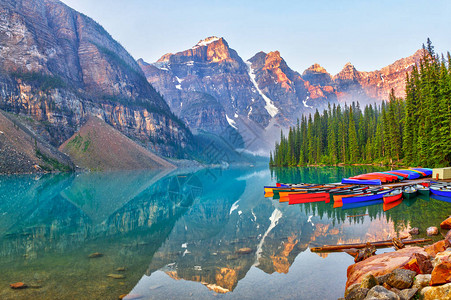 在十峰谷上日出在加拿大落基山脉的绿石湖上浮游着独木图片