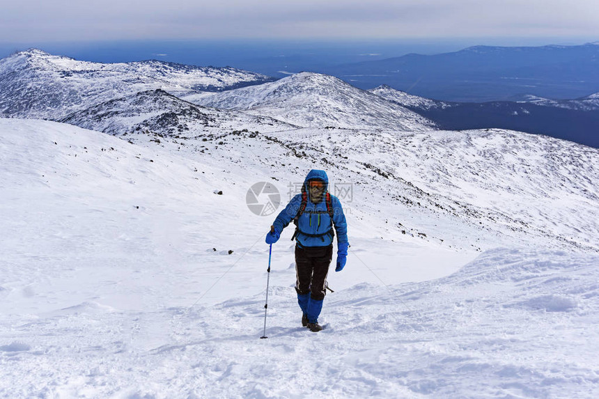 登山者登上白雪皑的山坡图片
