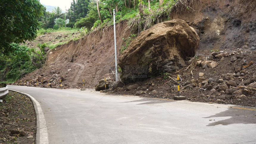 山体滑坡和山体滑坡泥土和岩石阻塞了道路被毁坏的农村道路滑坡在强大的洪水中受损倒在山上菲