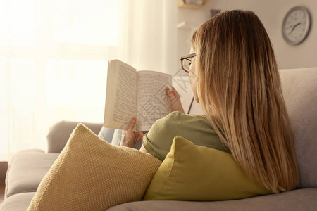 在家沙发上看书的年轻女子图片