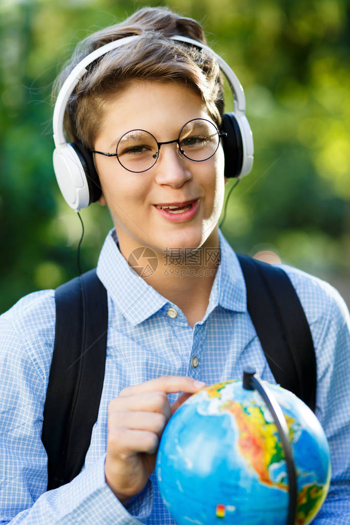 身穿蓝色衬衫背着包和工作簿的可爱小男孩图片