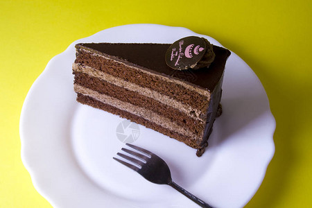 白色地方的美味蛋糕叉子被黄色黑隔开图片
