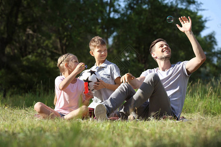 男人和他的小孩在公园里图片